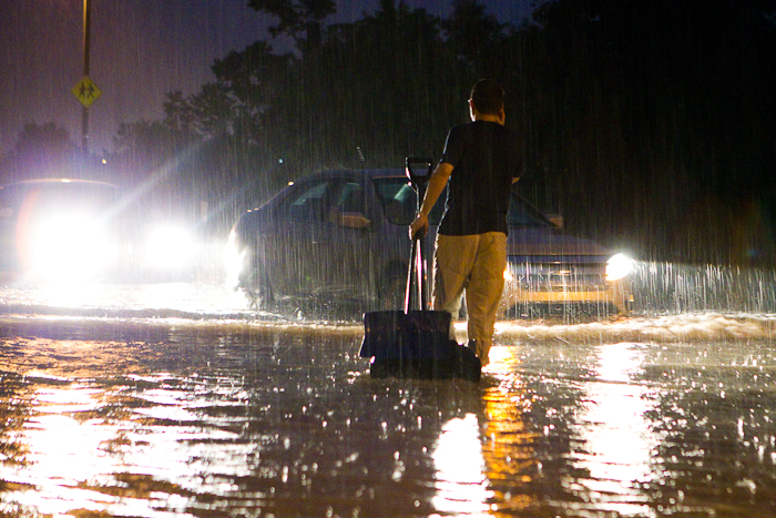 Un résident du quartier tente d'empêcher les véhicules de continuer leur chemin sur une rue entièrement inondée. Gatineau - Secteur Hull (Le Plateau), 24 juin 2011. (© Sébastien Lavallée, 2011)